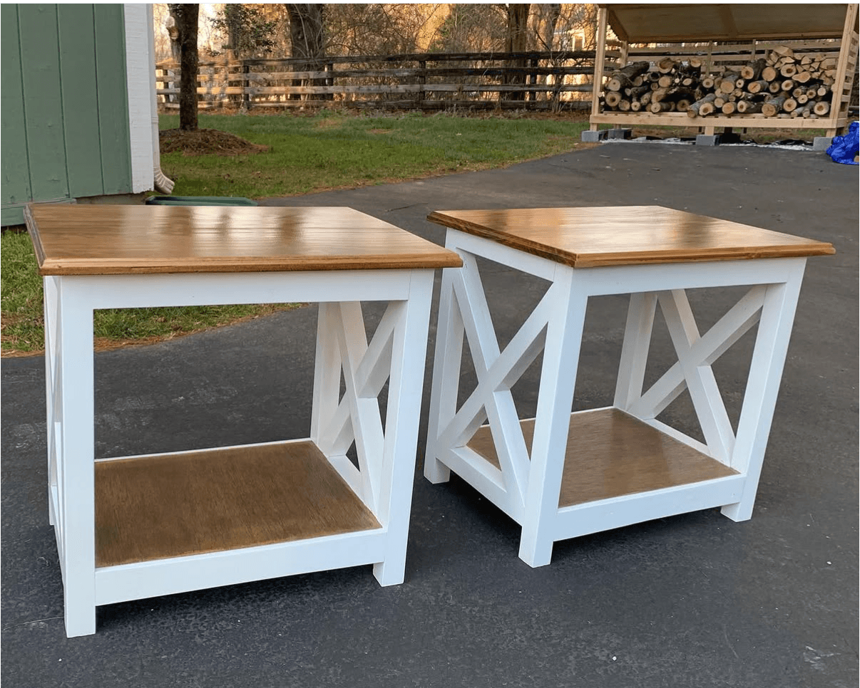 Pair of end tables with natural wood tops, white cross-braced frames, and lower shelves